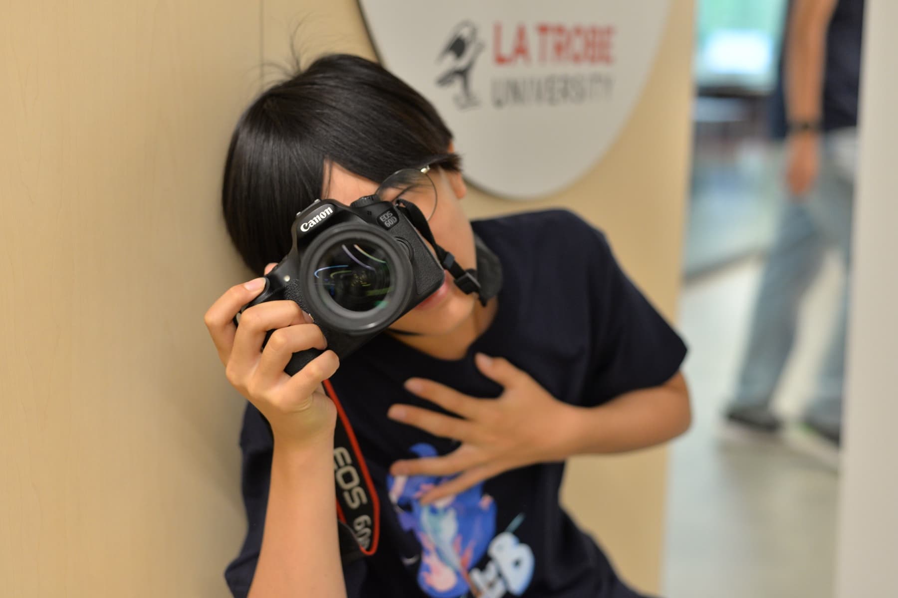 A teenager filming with a DSLR camera